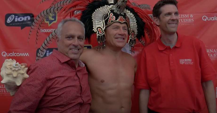 A man with a red shirt and a black headdress